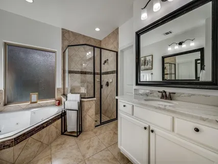a bathroom with a double vanity sink toilet mirror and bathtub