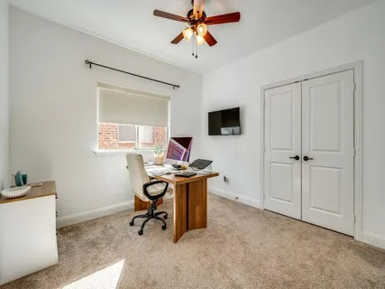 a view of a workspace with furniture and a window