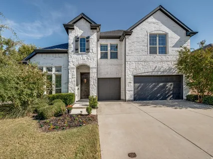 a front view of a house with yard and parking