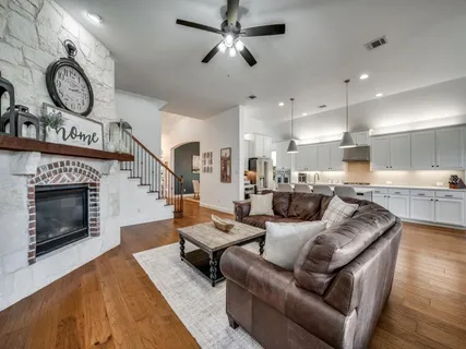a living room with furniture a fireplace and a ceiling fan