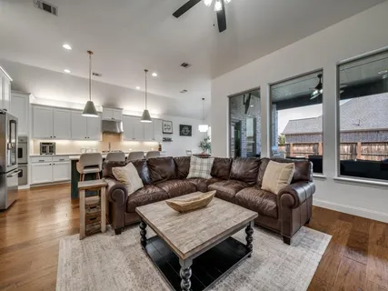 a living room with furniture and a wooden floor