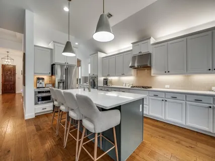 a kitchen with stainless steel appliances granite countertop a stove a sink dishwasher and a refrigerator with wooden floor