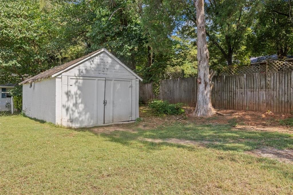2523 Maple Road Southeast Rome, GA 30161 - Photo 23 of 30 a view of a small yard in front of a house with large tree and wooden fence