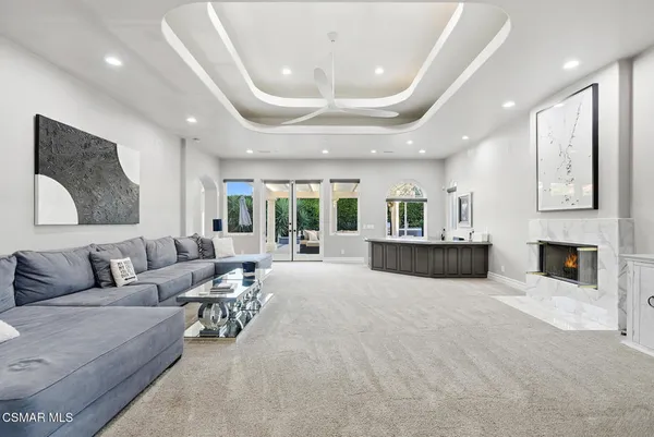 a spacious bedroom with a bed a chandelier and dresser