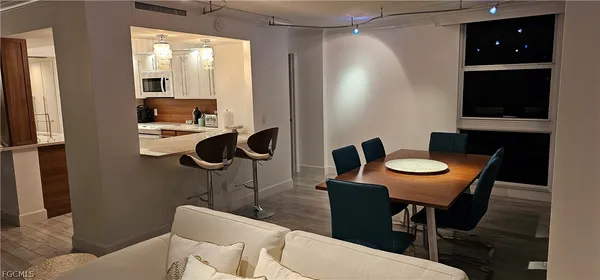 a kitchen with a table chairs and a flat screen tv