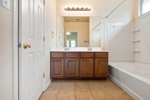 a bathroom with a tub a sink and a mirror