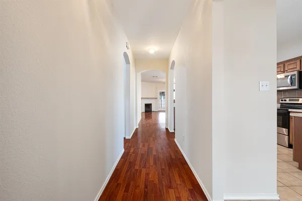 a view of a hallway with wooden floor and staircase