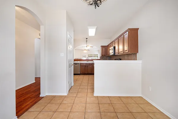 a view of kitchen with kitchen island microwave and cabinets