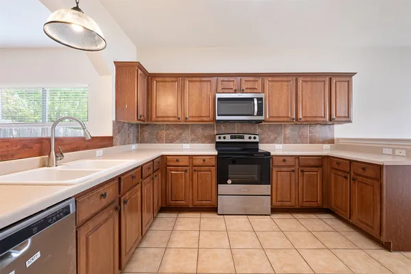 a kitchen with a sink stove top oven and microwave