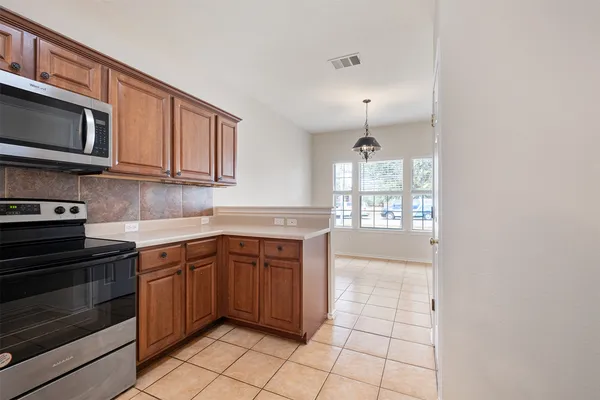 a kitchen with stainless steel appliances granite countertop a stove a sink and a microwave