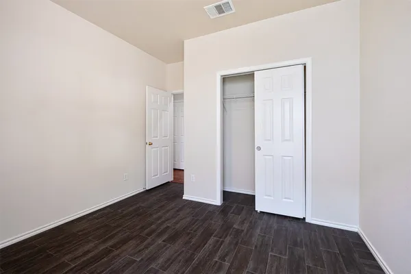 an empty room with wooden floor and closet