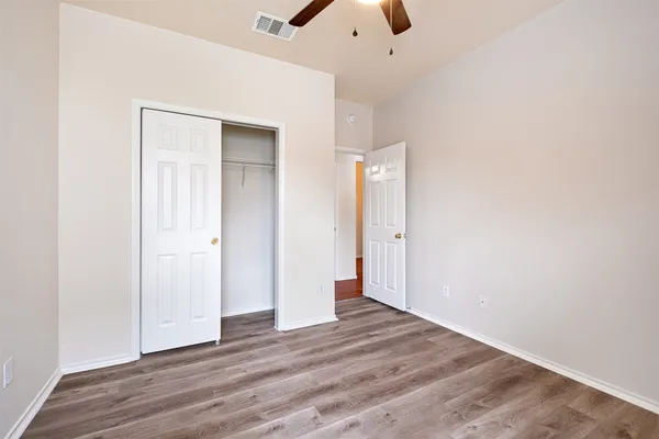 an empty room with wooden floor and closet