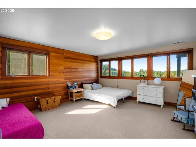 a bedroom with furniture and a large window