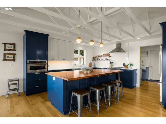 a kitchen with stainless steel appliances granite countertop a sink a stove and a refrigerator