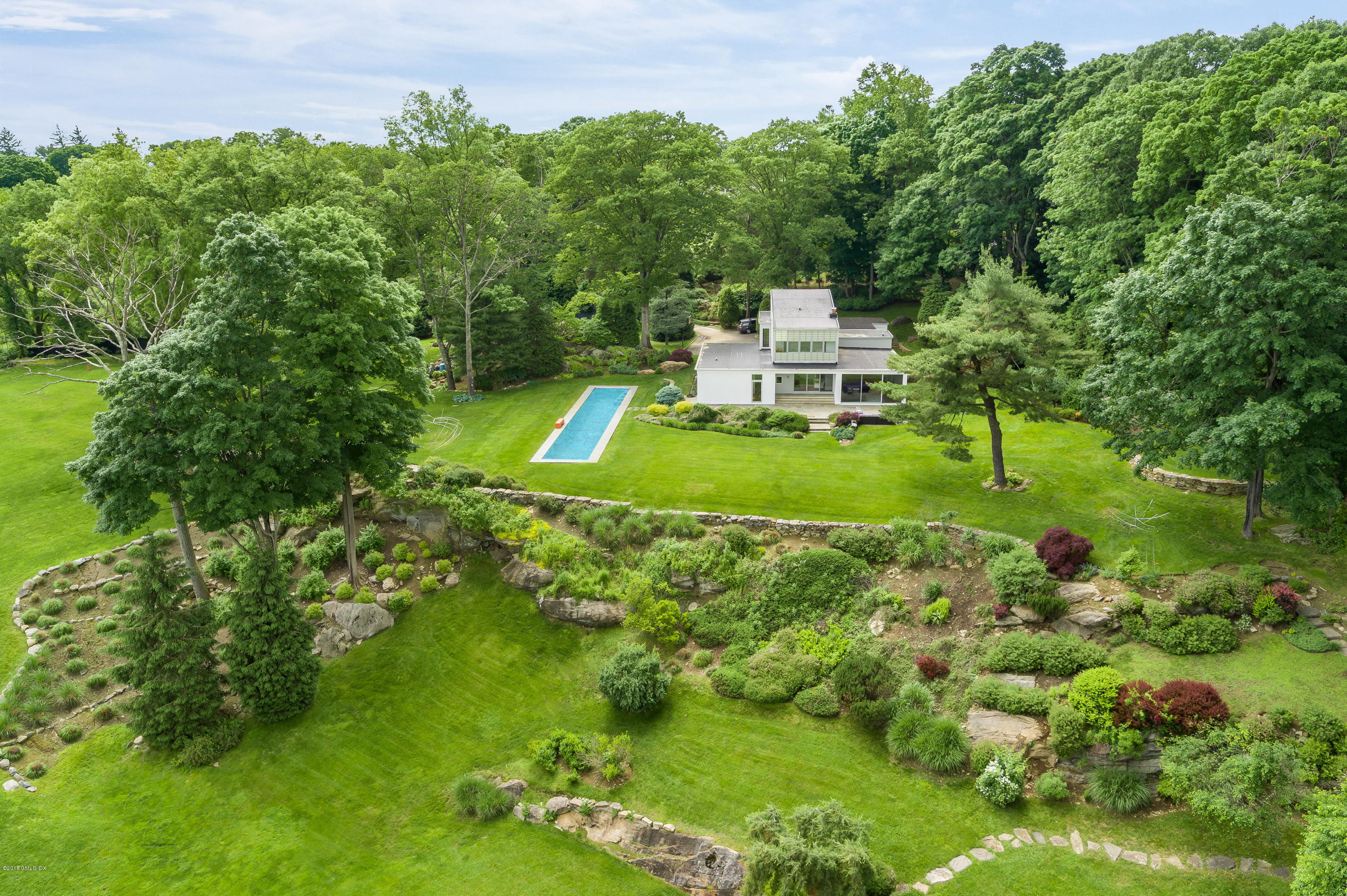 491 Riversville Road Greenwich, CT 06831 - Photo 12 of 30 a view of a house with a big yard and large trees