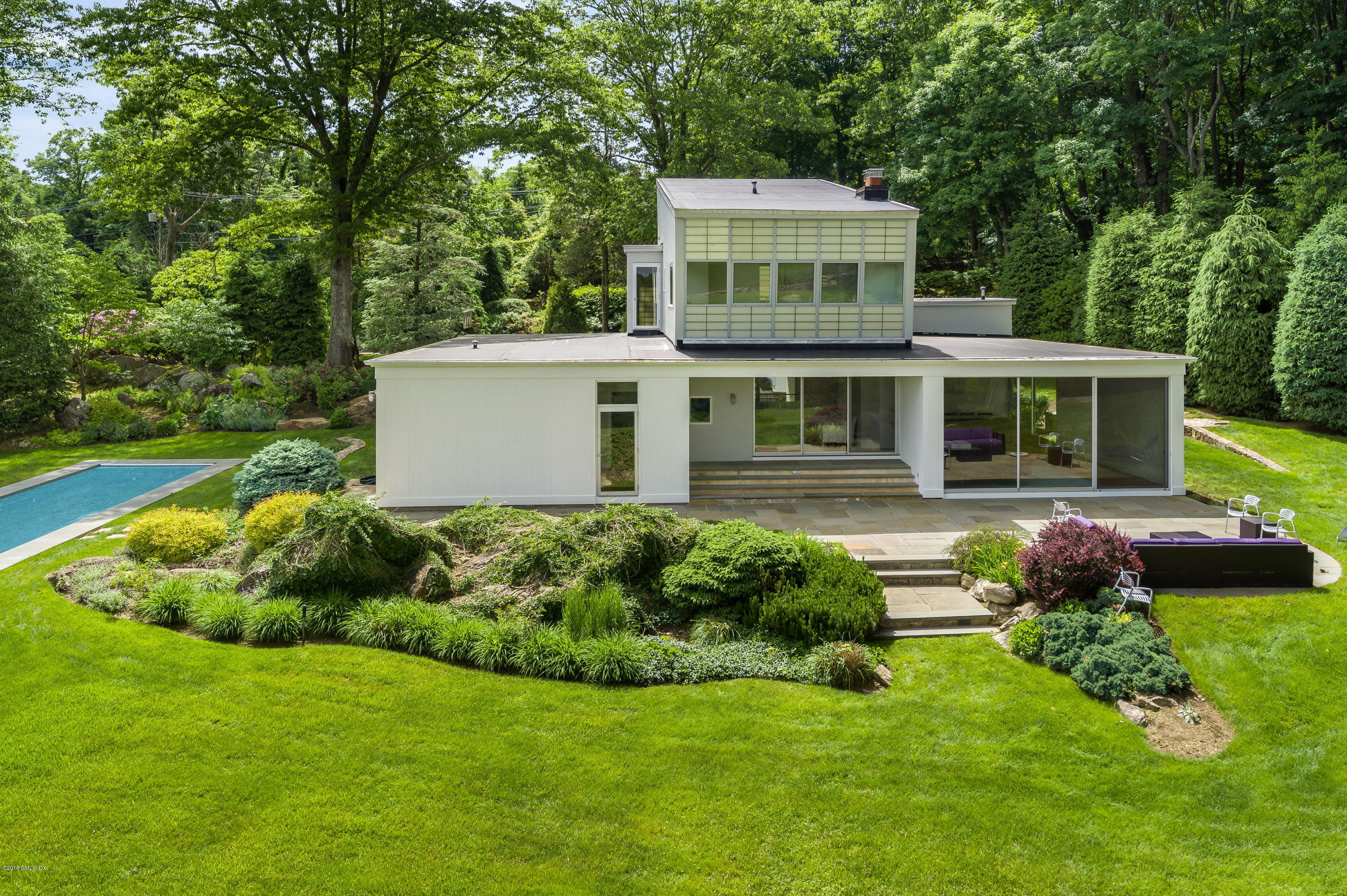 491 Riversville Road Greenwich, CT 06831 - Photo 2 of 30 a front view of a house with a garden