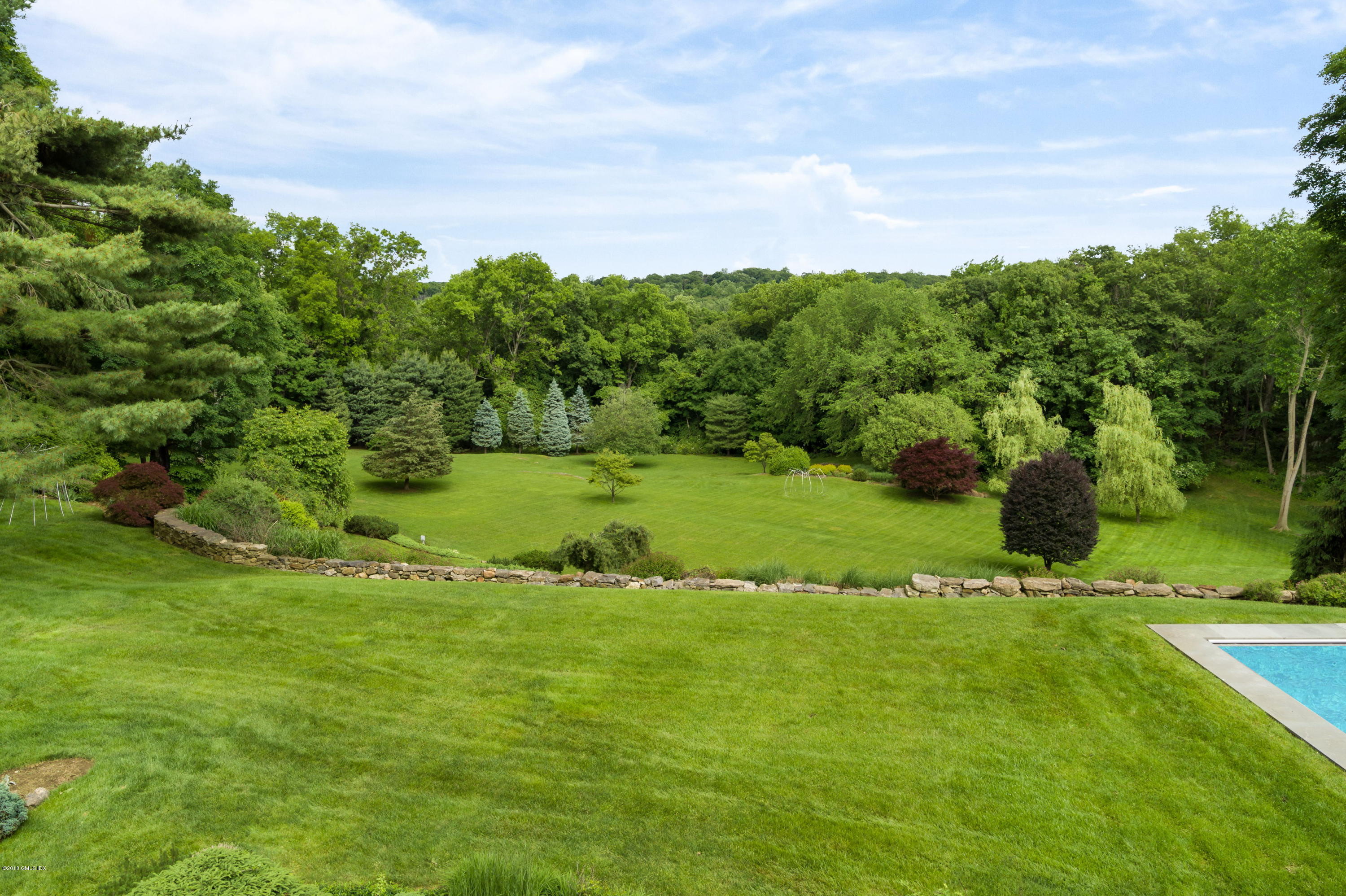 491 Riversville Road Greenwich, CT 06831 - Photo 5 of 30 a view of a grassy field with trees