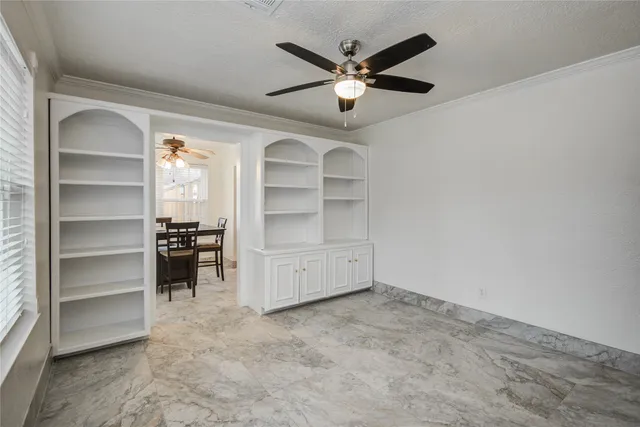 a view of a room with a ceiling fan and window