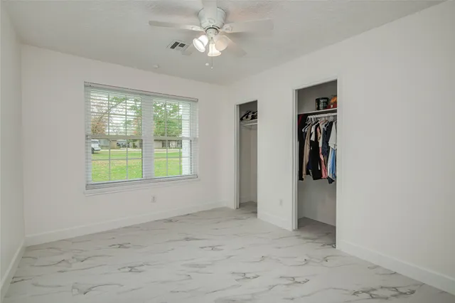 an empty room with a chandelier fan