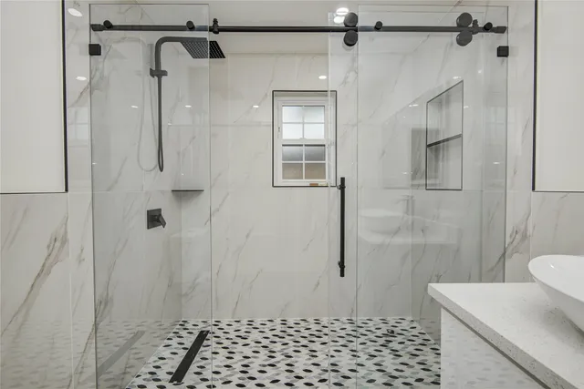 a bathroom with a shower sink and mirror