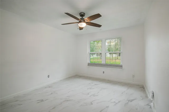 an empty room with closet and ceiling fan