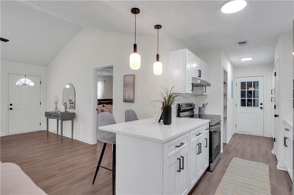 592 Linda Lane Powder Springs, GA 30127 - Photo 11 of 21 a view of kitchen island with sink wooden floor and furniture