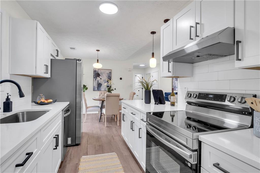 592 Linda Lane Powder Springs, GA 30127 - Photo 12 of 21 a kitchen with stainless steel appliances granite countertop a sink a stove and a refrigerator