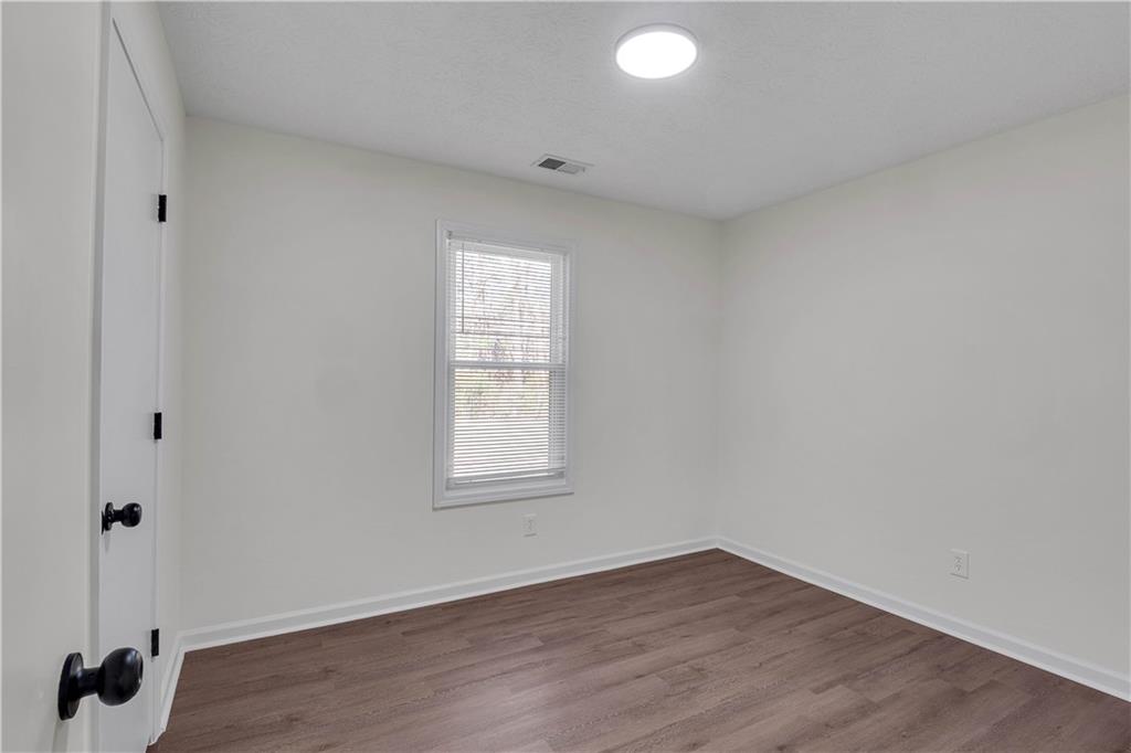 592 Linda Lane Powder Springs, GA 30127 - Photo 16 of 21 an empty room with wooden floor and windows