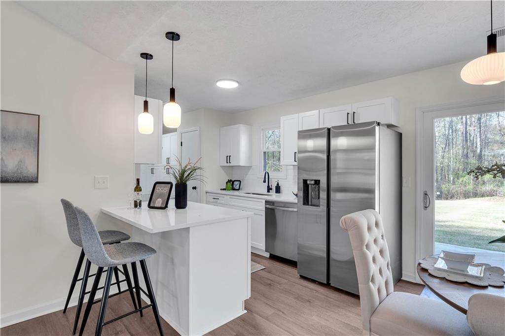 592 Linda Lane Powder Springs, GA 30127 - Photo 10 of 21 a kitchen with stainless steel appliances a dining table chairs and refrigerator