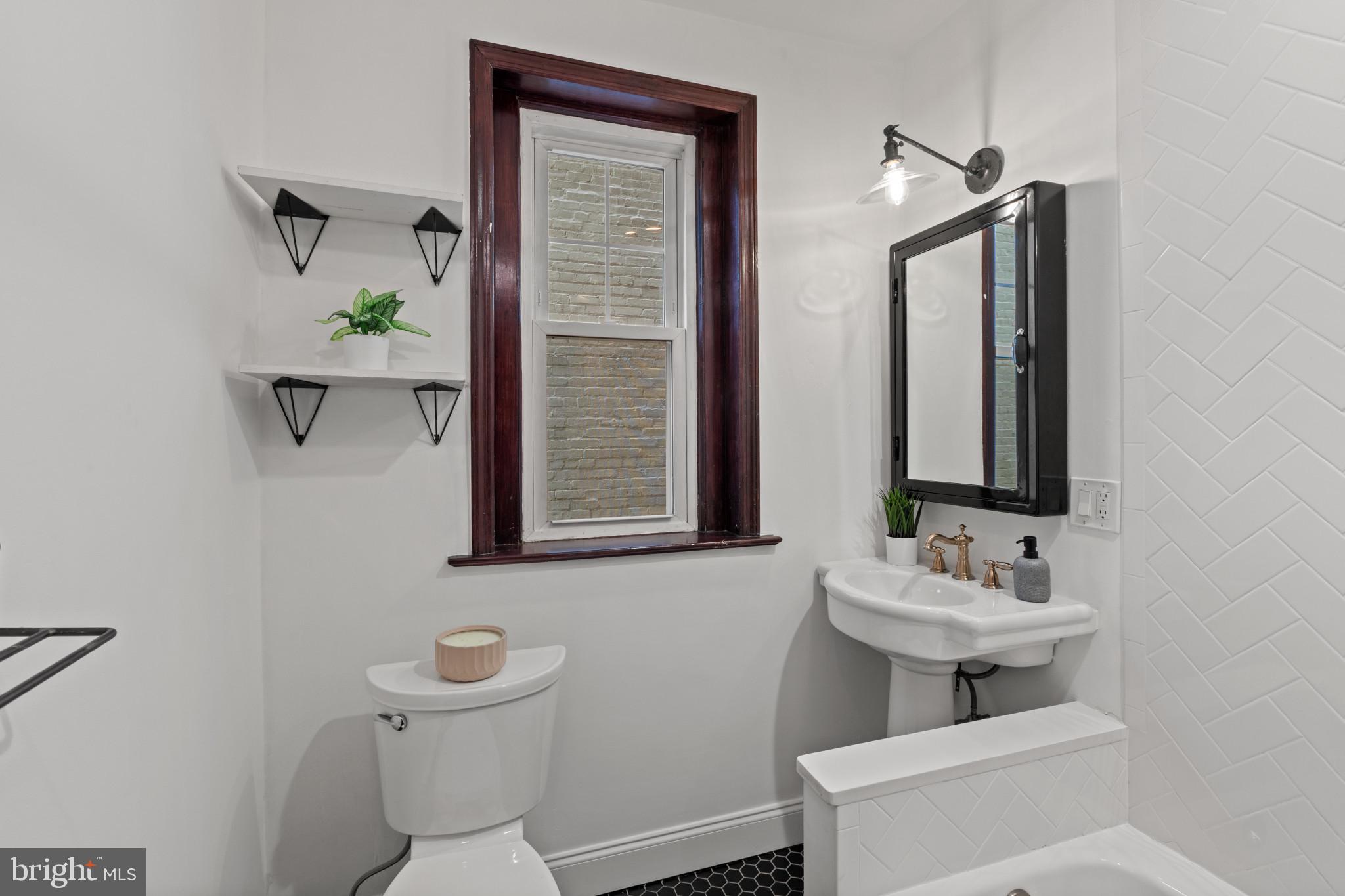 1332 15th Street Northwest, Unit 2 Washington, DC 20005 - Photo 22 of 28 a bathroom with a toilet sink and mirror