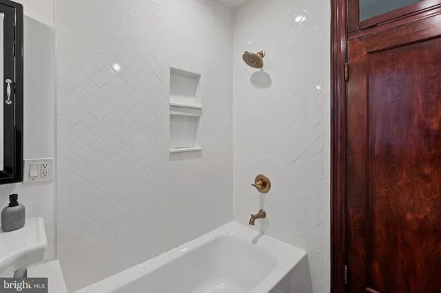 a bathroom with a white bath tub and a sink