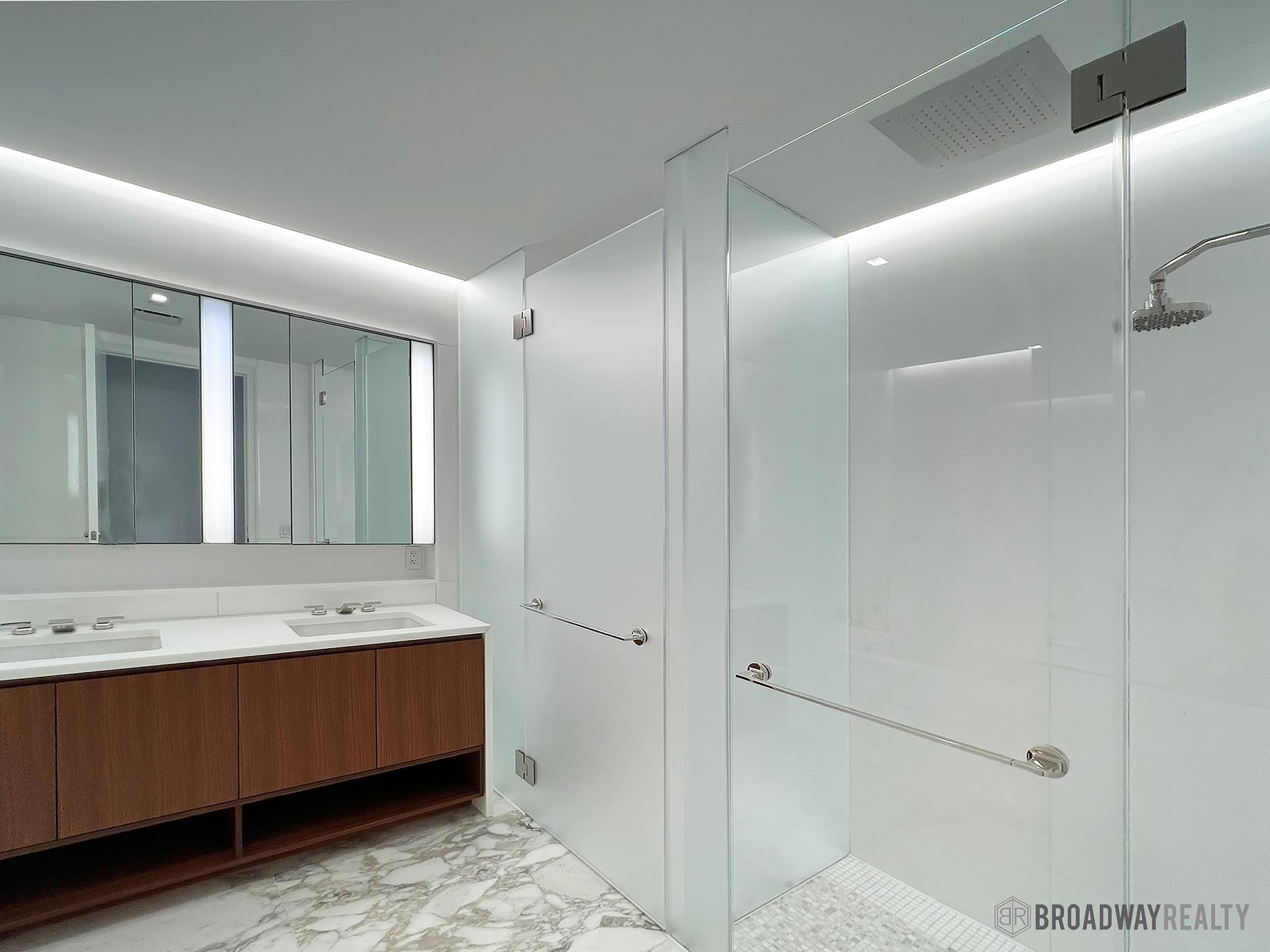 1289 Lexington Avenue, Unit 6B Manhattan, NY 10028 - Photo 16 of 24 a bathroom with a double vanity sink and mirror