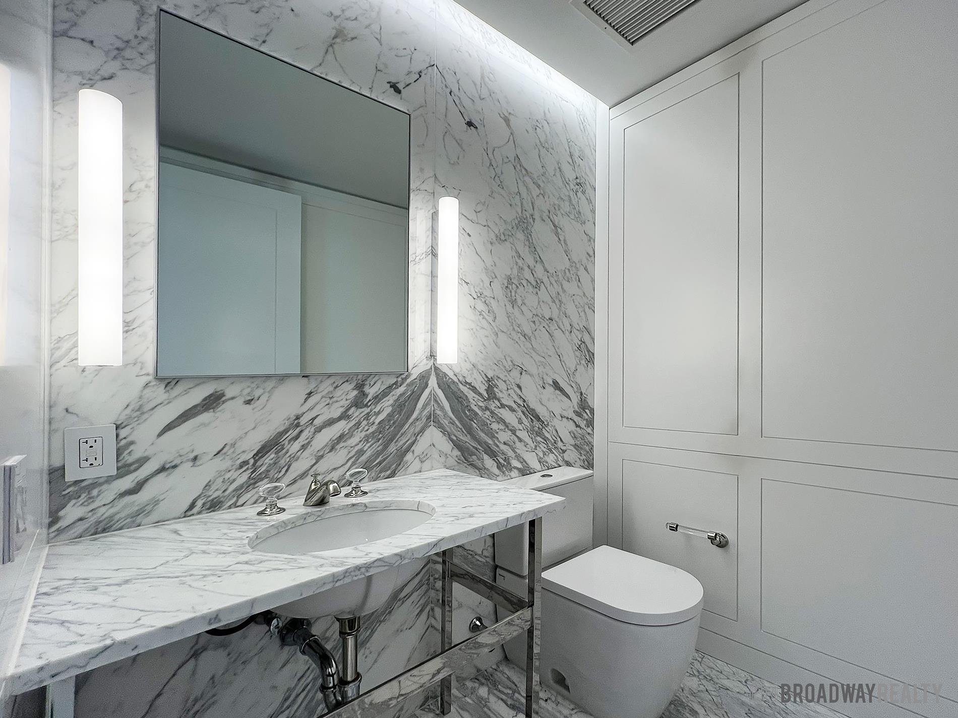 1289 Lexington Avenue, Unit 6B Manhattan, NY 10028 - Photo 18 of 24 a bathroom with a granite countertop sink a toilet and a mirror