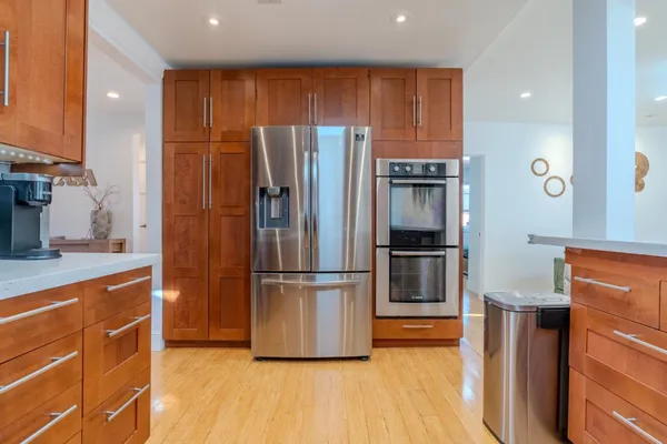 a kitchen with stainless steel appliances granite countertop a refrigerator and a stove