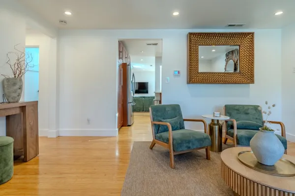 a living room with furniture and a wooden floor