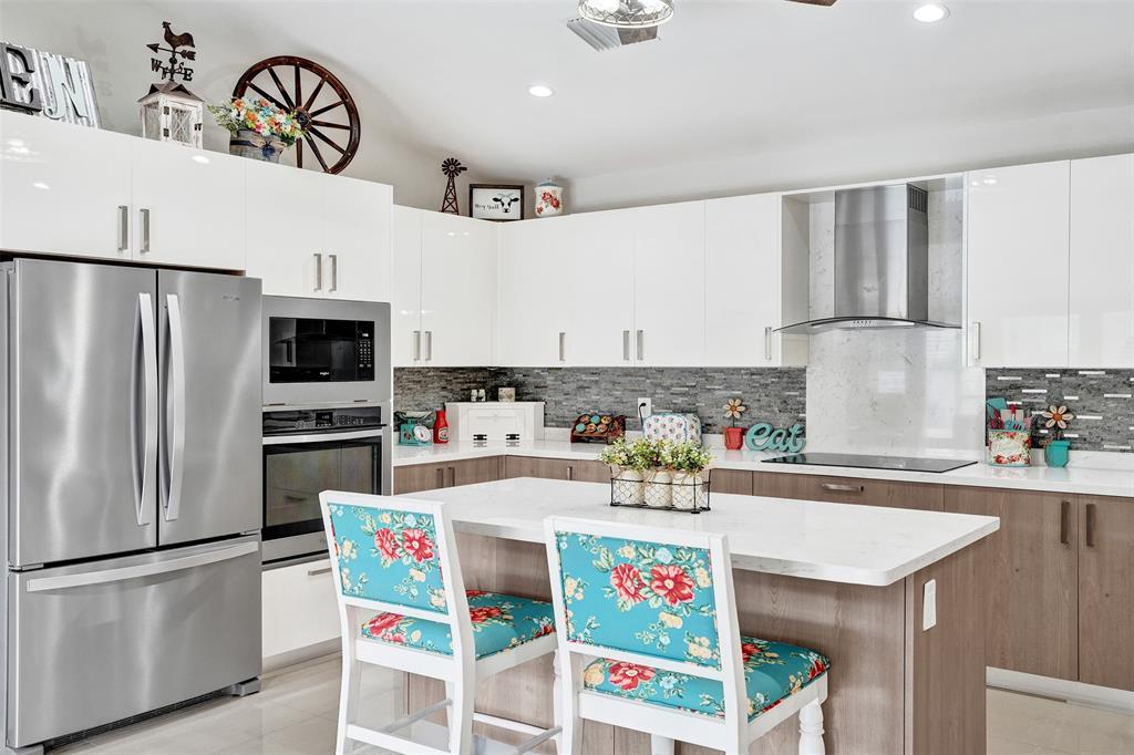 5076 Northwest 84th Road Coral Springs, FL 33067 - Photo 11 of 74 a kitchen with a refrigerator a stove a sink and cabinets
