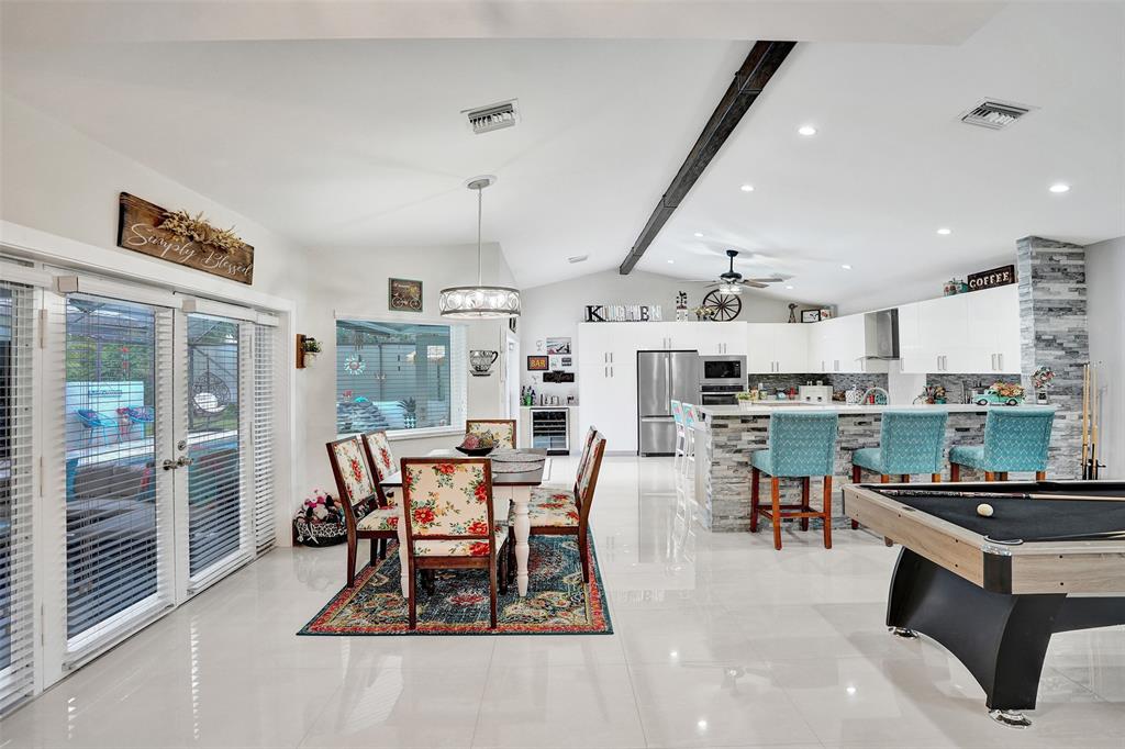 5076 Northwest 84th Road Coral Springs, FL 33067 - Photo 16 of 74 a dining room with stainless steel appliances kitchen island granite countertop a table and chairs in it