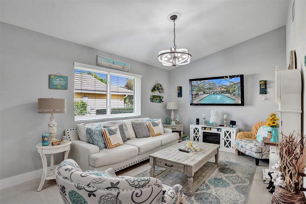 5076 Northwest 84th Road Coral Springs, FL 33067 - Photo 20 of 74 a living room with furniture chandelier and a window