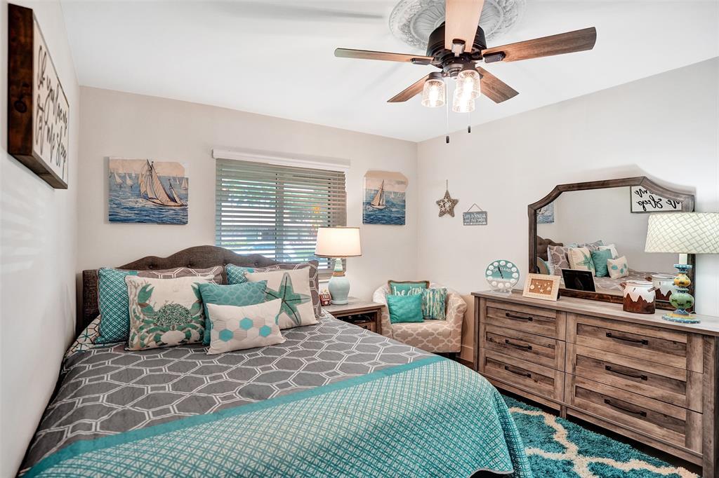 5076 Northwest 84th Road Coral Springs, FL 33067 - Photo 35 of 74 a bedroom with a bed a chandelier and a dresser