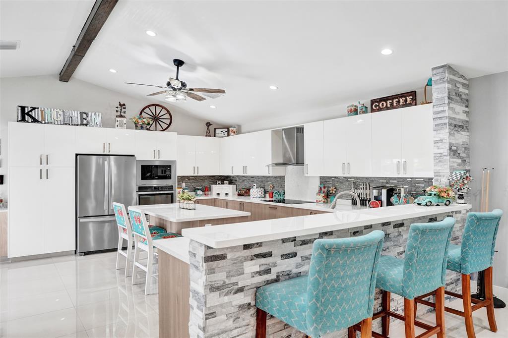 5076 Northwest 84th Road Coral Springs, FL 33067 - Photo 9 of 74 a kitchen with a stove a refrigerator and a table