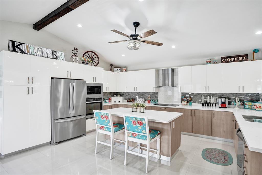 5076 Northwest 84th Road Coral Springs, FL 33067 - Photo 10 of 74 a kitchen with a refrigerator a sink dishwasher a dining table and chairs with wooden floor