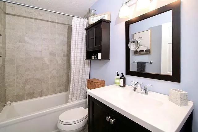 a bathroom with a sink vanity toilet and shower