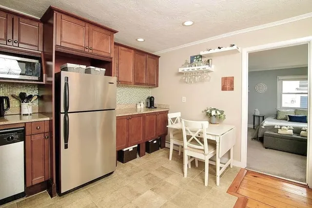 a kitchen with stainless steel appliances granite countertop a refrigerator and a stove top oven
