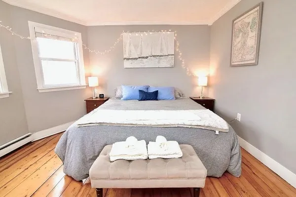a bedroom with a bed and wooden floor