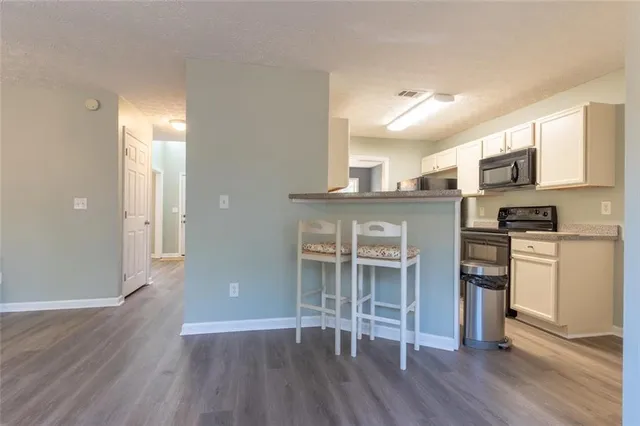 a view of kitchen with wooden floor and electronic appliances