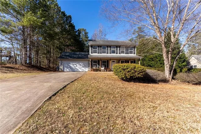 a front view of a building with large trees