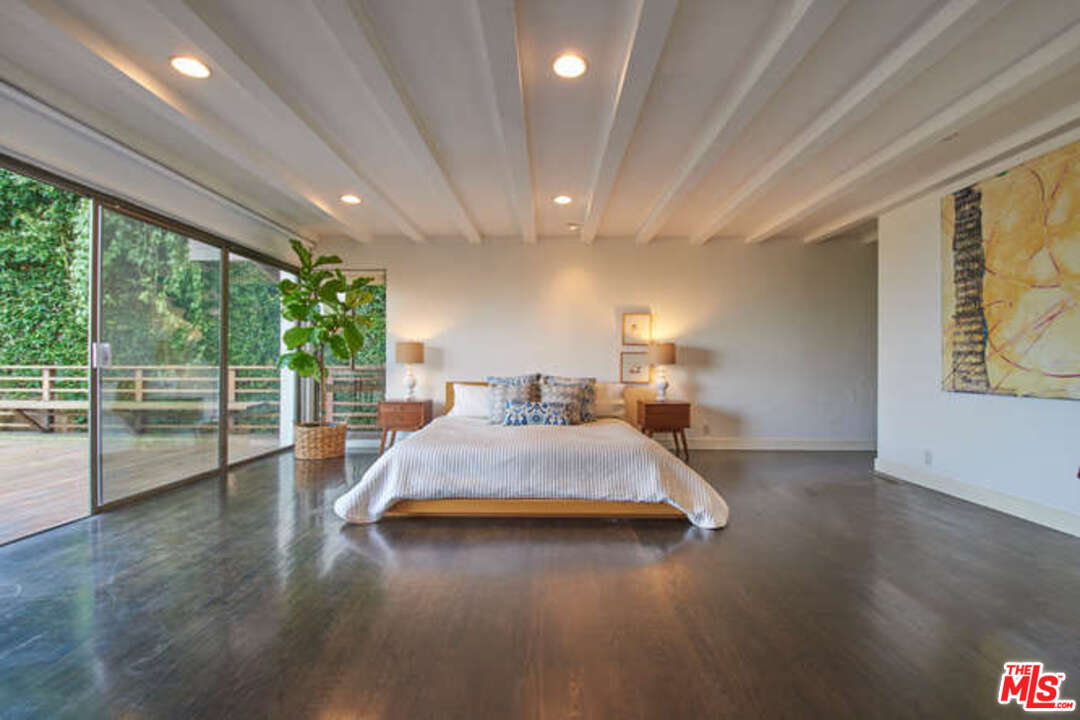 7050 Dume Drive Malibu, CA 90265 - Photo 8 of 13 a spacious bedroom with a large bed and a wooden floor