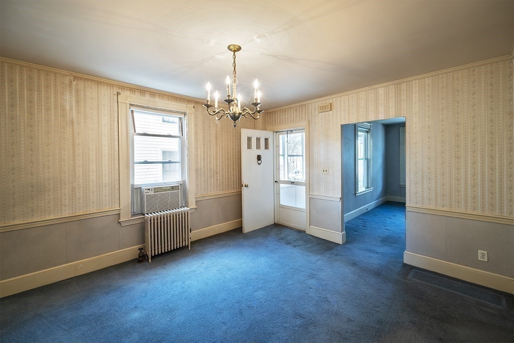 72 Rice Street, Unit 72 Cambridge, MA 02140 - Photo 6 of 20 an empty room with wooden floor chandelier and windows