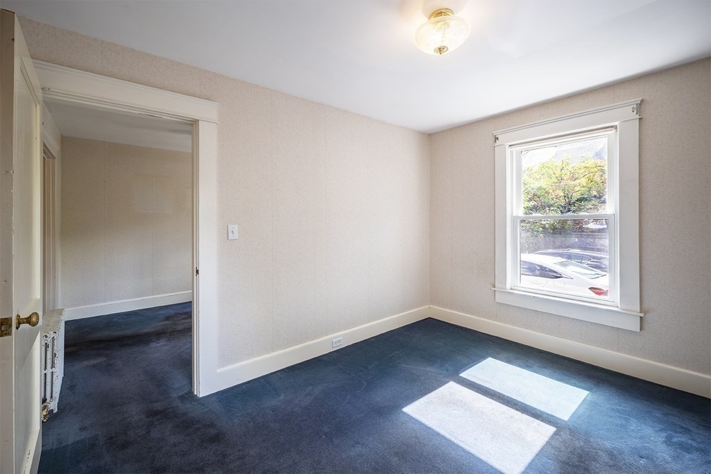 72 Rice Street, Unit 72 Cambridge, MA 02140 - Photo 10 of 20 an empty room with wooden floor and windows