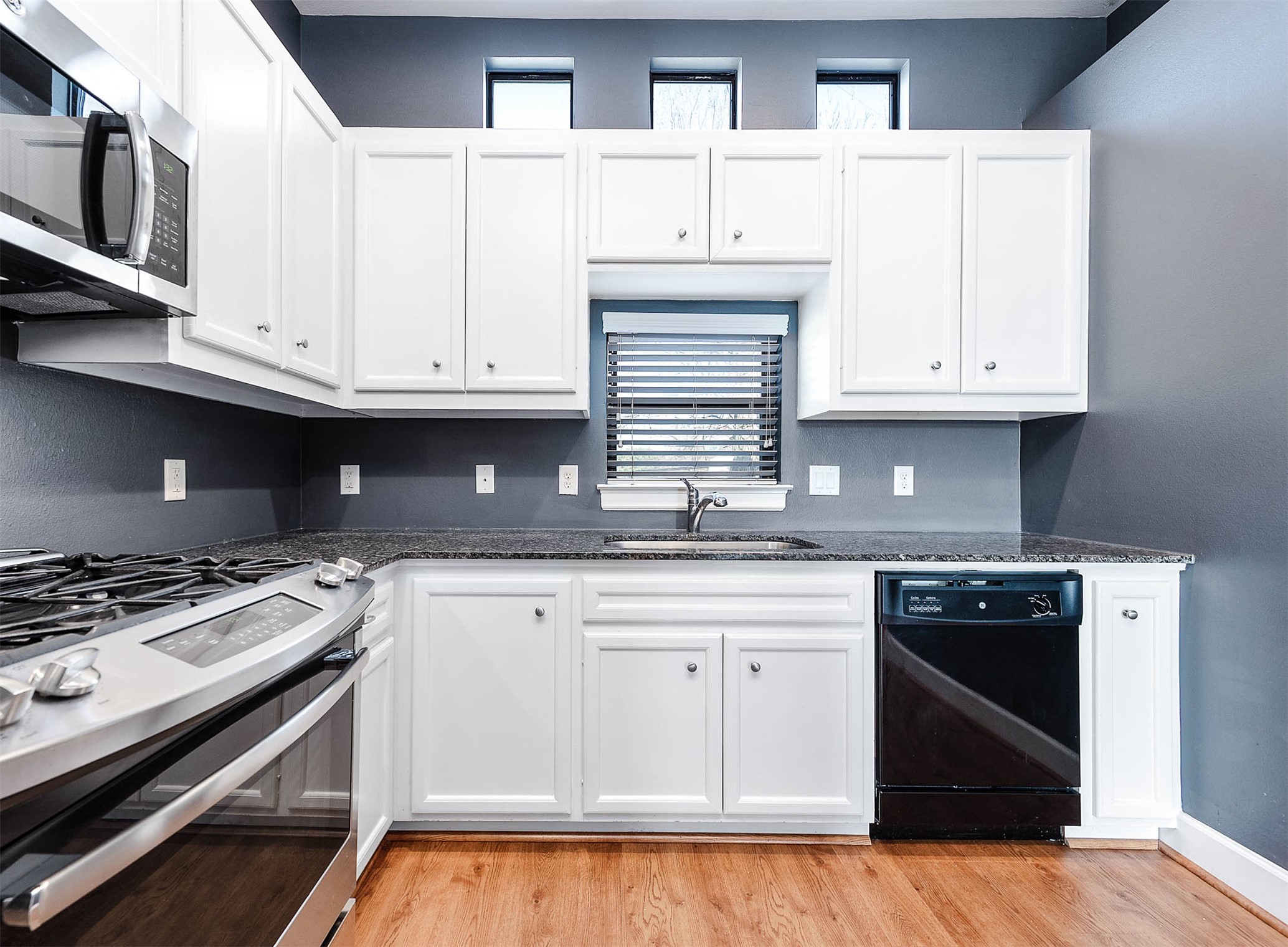 7650 Springhill Street, Unit 704 Houston, TX 77021 - Photo 11 of 23 a kitchen with granite countertop a stove sink and cabinets